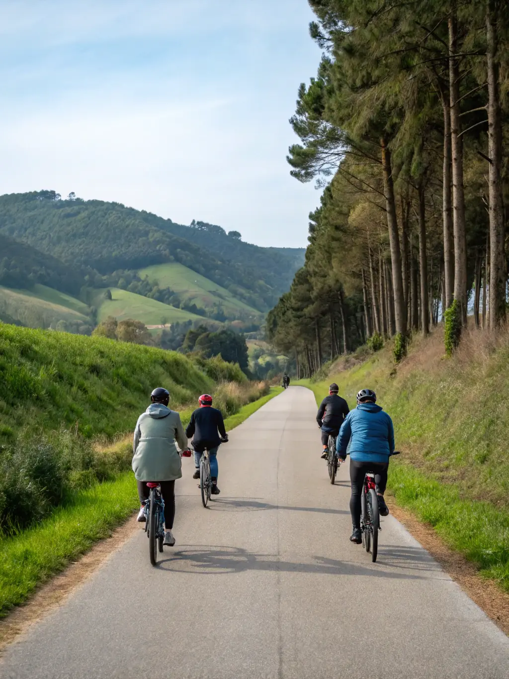 People of different ages and abilities cycling together on a scenic bike path, highlighting community engagement.